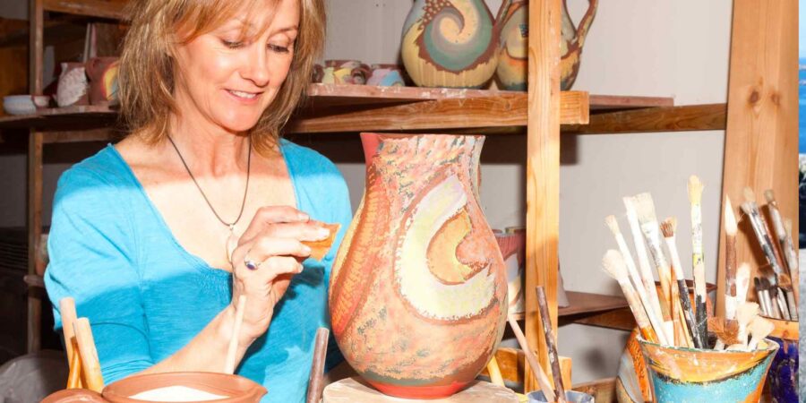 Hedi O'Neill ag péinteáil earraí potaireachta i Dingle Pottery