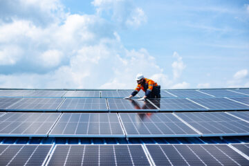 Engineer service check installation solar cell on the roof of factory.